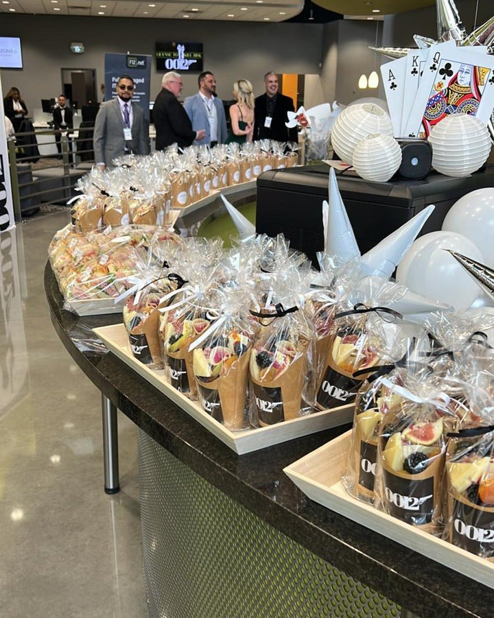 Buffet setup with wrapped food items and people in a casual setting