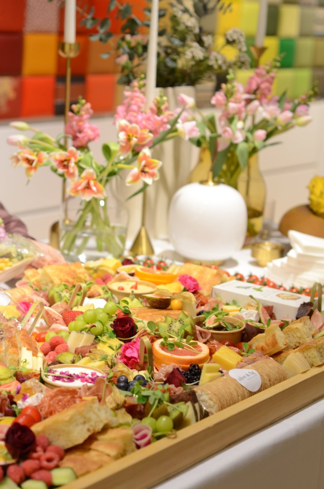 Colorful appetizer platter with flowers and a colorful wall in the background
